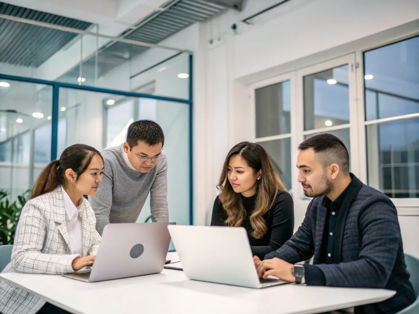 A photograph depicting a group of employees collaborating in a training session at a modern office, emphasizing teamwork and in-person interaction, reflecting Bessa Consultores' closed group training format for companies.