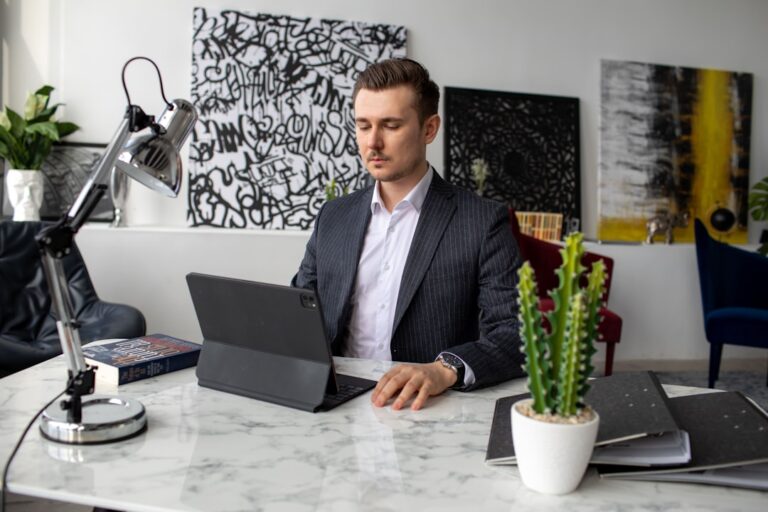 Um Homem Sentando Em Um Mesa Com Um Laptop e12ae98hbY