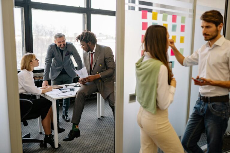 Office environment with diverse team members brainstorming and collaborating on a project.