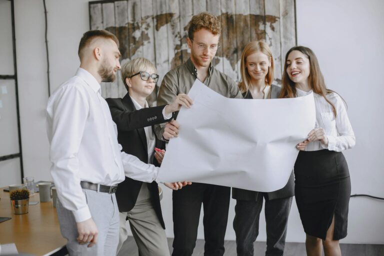 Group of professionals in an office setting analyzing project plans together.