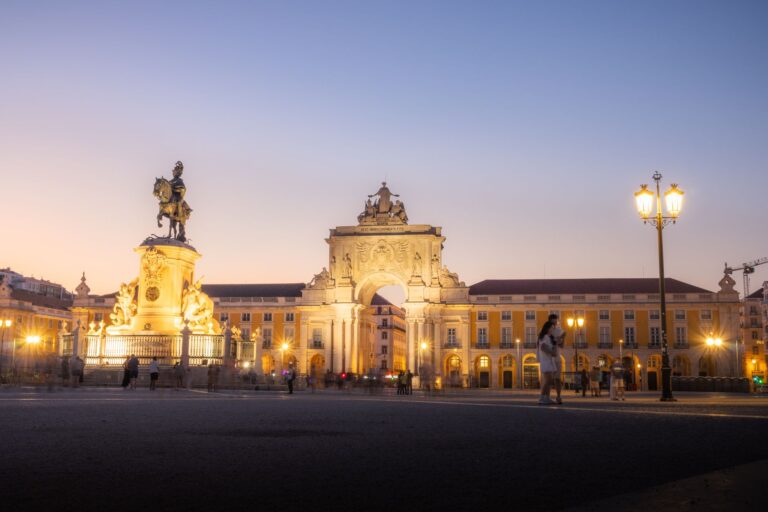 Twilight view of Praça do Comércio in Lisbon, showcasing Arco da Rua Augusta and equestrian statue.