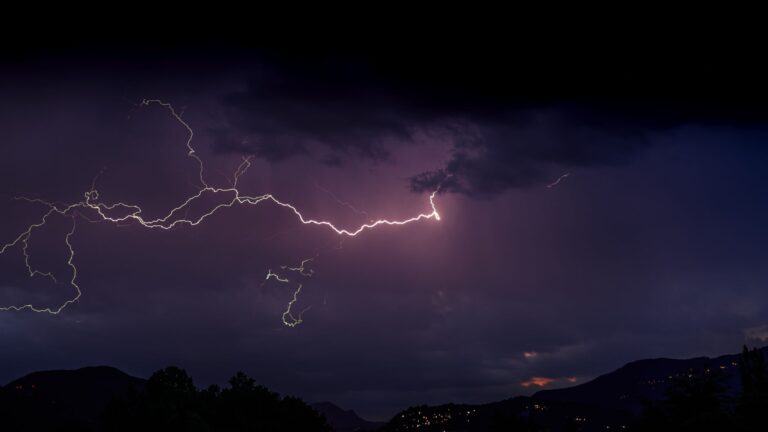 Stunning lightning bolt captured during a stormy night over Lake Como, Italy, illuminating the sky.
