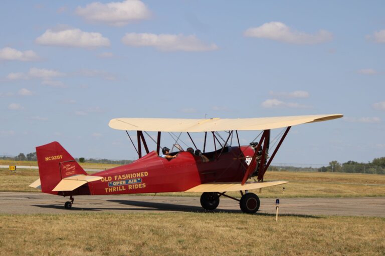 A classic red biplane offering thrill rides on a sunny day at Circleville airfield.