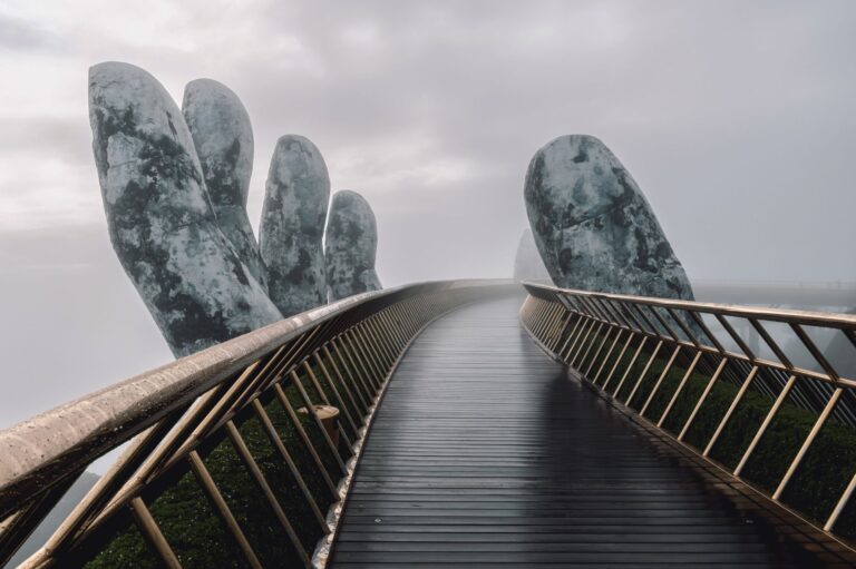 The Golden Bridge in Da Nang, Vietnam, enveloped in fog, showcasing its iconic giant hands.